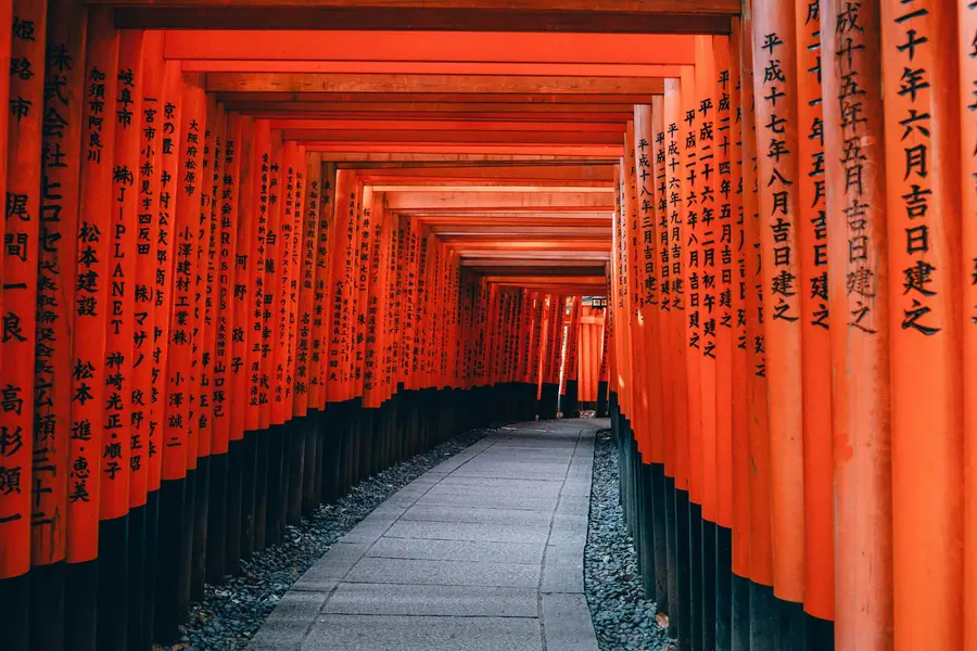 Tunnel de portiques torii vermillon au sanctuaire Fushimi Inari, à Kyoto